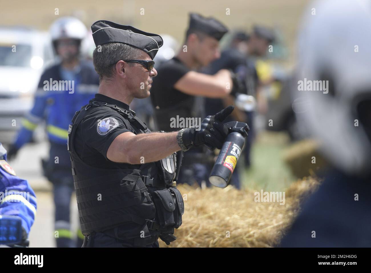A police man holds a cannister of tear gas (pepper spray - traangas - lacrymogene) during a protest action, in the 16th stage of the 105th edition of the Tour de France cycling race, 218km from Carcassone to Bagneres-de-Luchon, France, Tuesday 24 July 2018. This year's Tour de France takes place from July 7th to July 29th. BELGA PHOTO YORICK JANSENS - FRANCE OUT  Stock Photo
