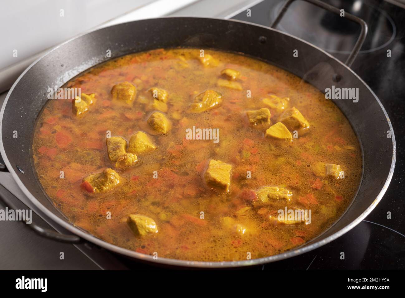 Pan for paellas with vegetables, ingredients and meat taking