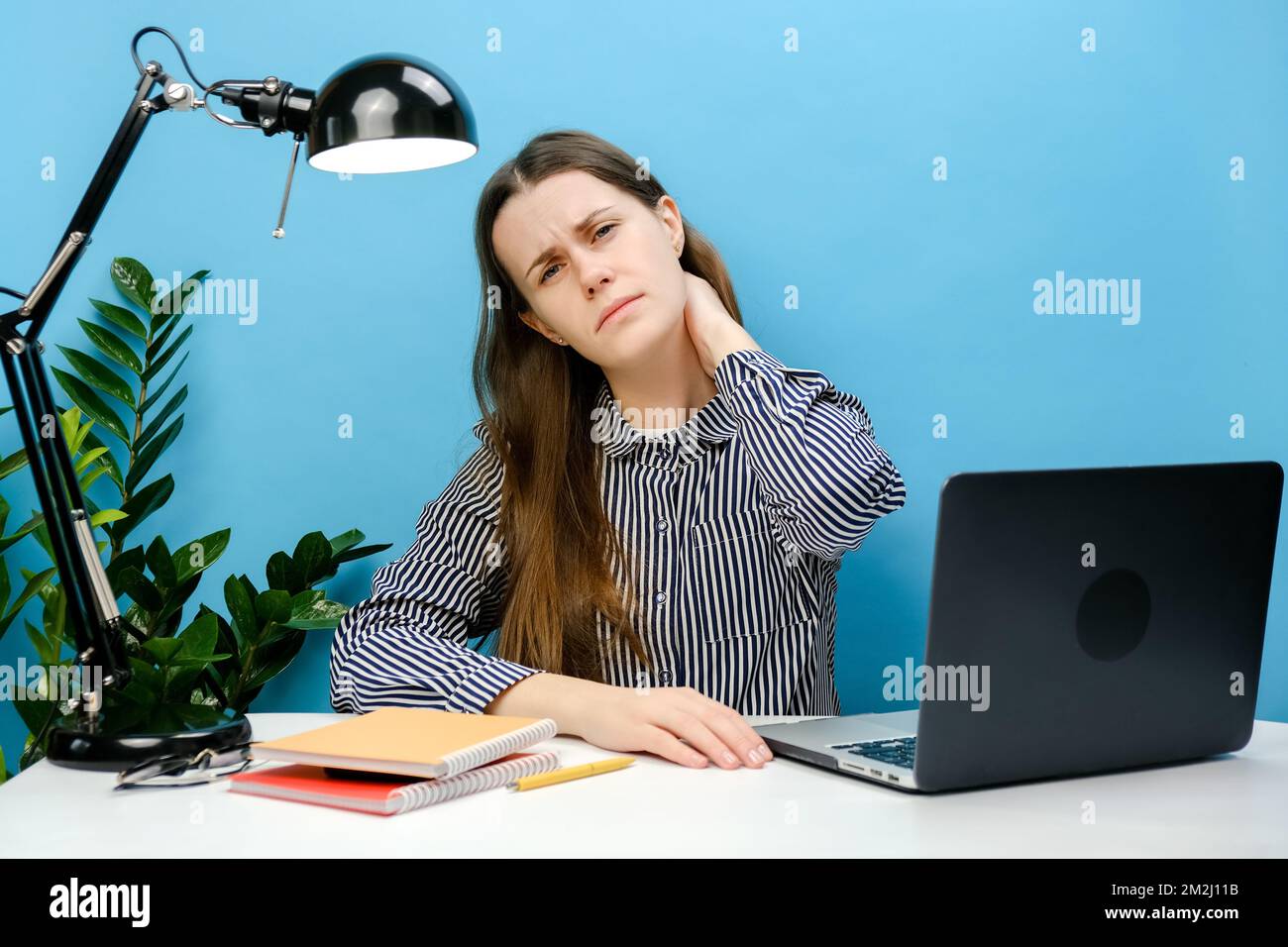 Sick young employee business woman sitting at workplace with laptop