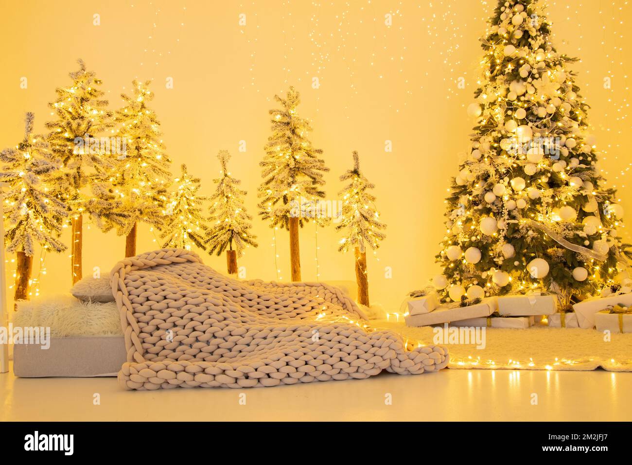 Christmas tree with gifts at home with luminous garlands, Christmas decorations at home, holiday Stock Photo