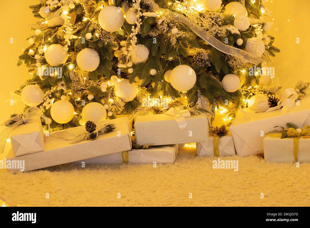 Christmas tree with gifts at home with luminous garlands, Christmas decorations at home, holiday Stock Photo