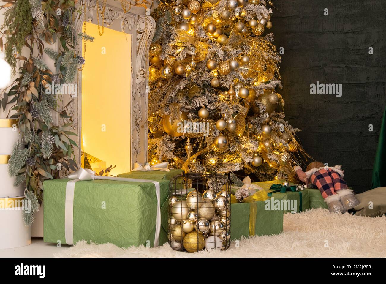 Christmas tree with gifts at home with luminous garlands, Christmas decorations at home Stock Photo