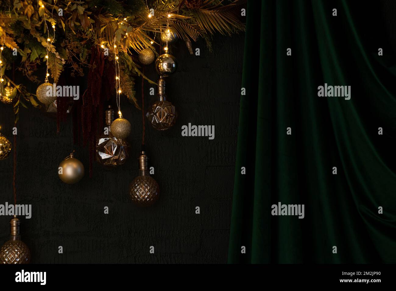 A Christmas tree wreath with garlands and toys hangs on a green wall ...
