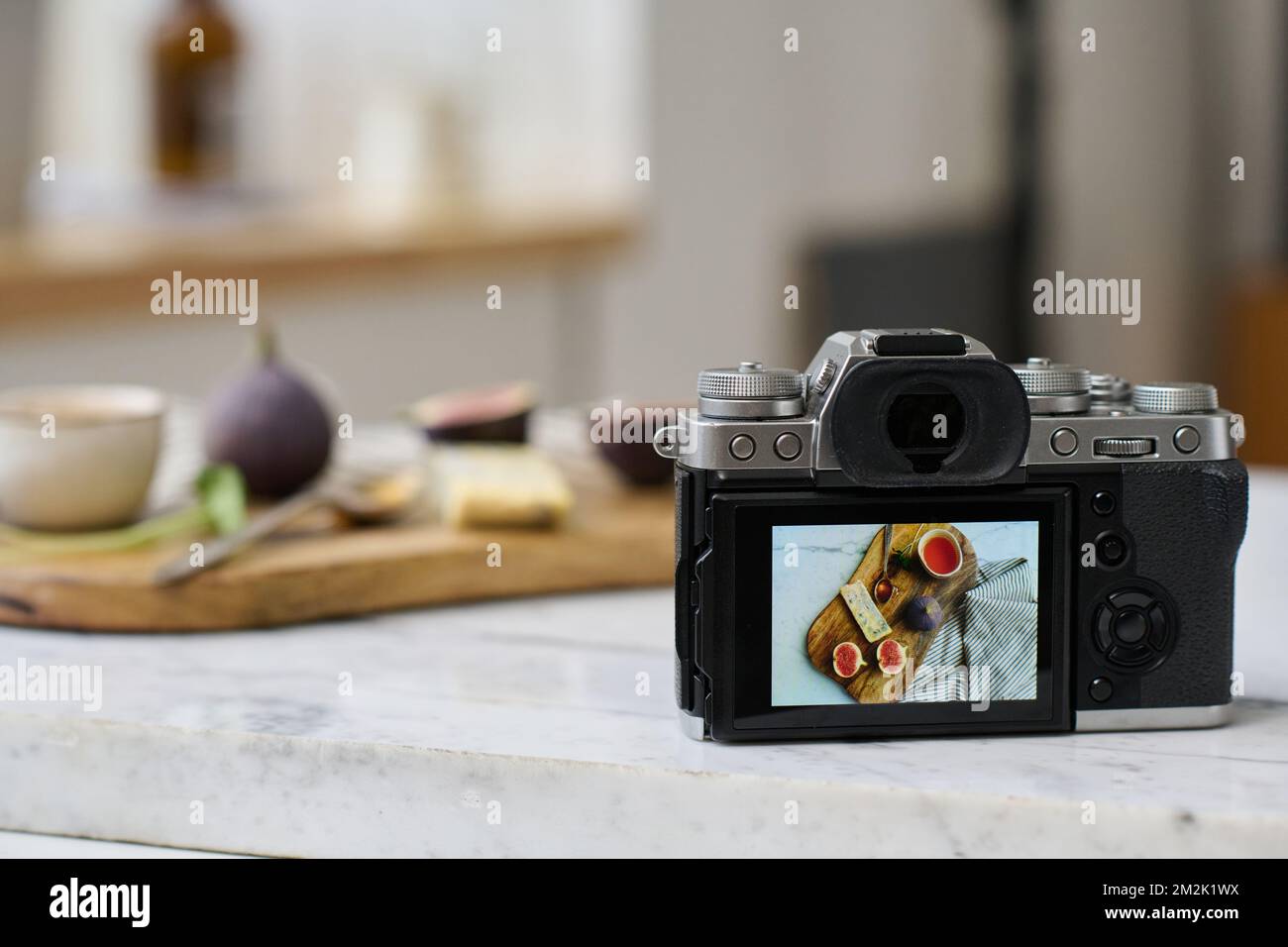 Close-up of professional photo camera on table with still life picture on screen using for photographing professional photos Stock Photo