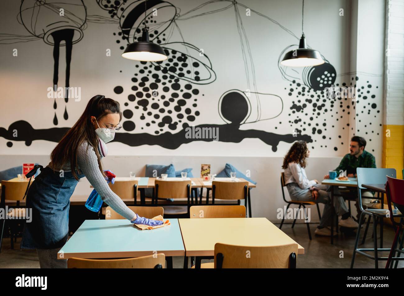 Full lengh side view young waitress working in restaurant cleaning table Stock Photo Alamy