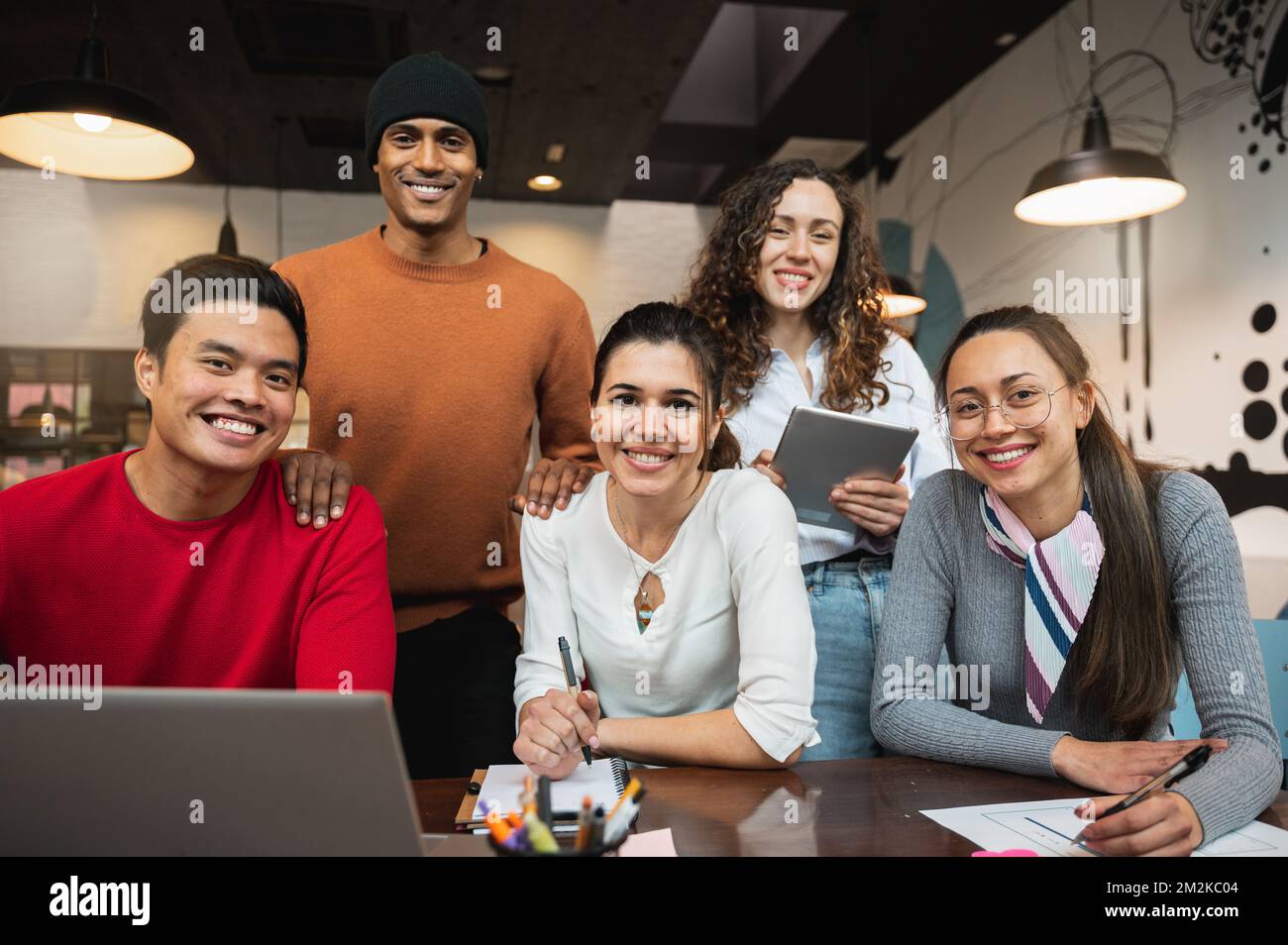 Multiracial group of five young people looking at camera smiling. Stock Photo