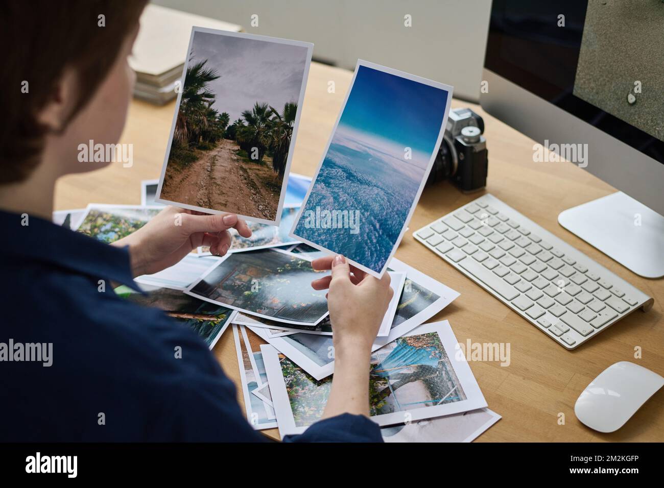 Young designer working with professional photos during work at her workplace with computer Stock Photo