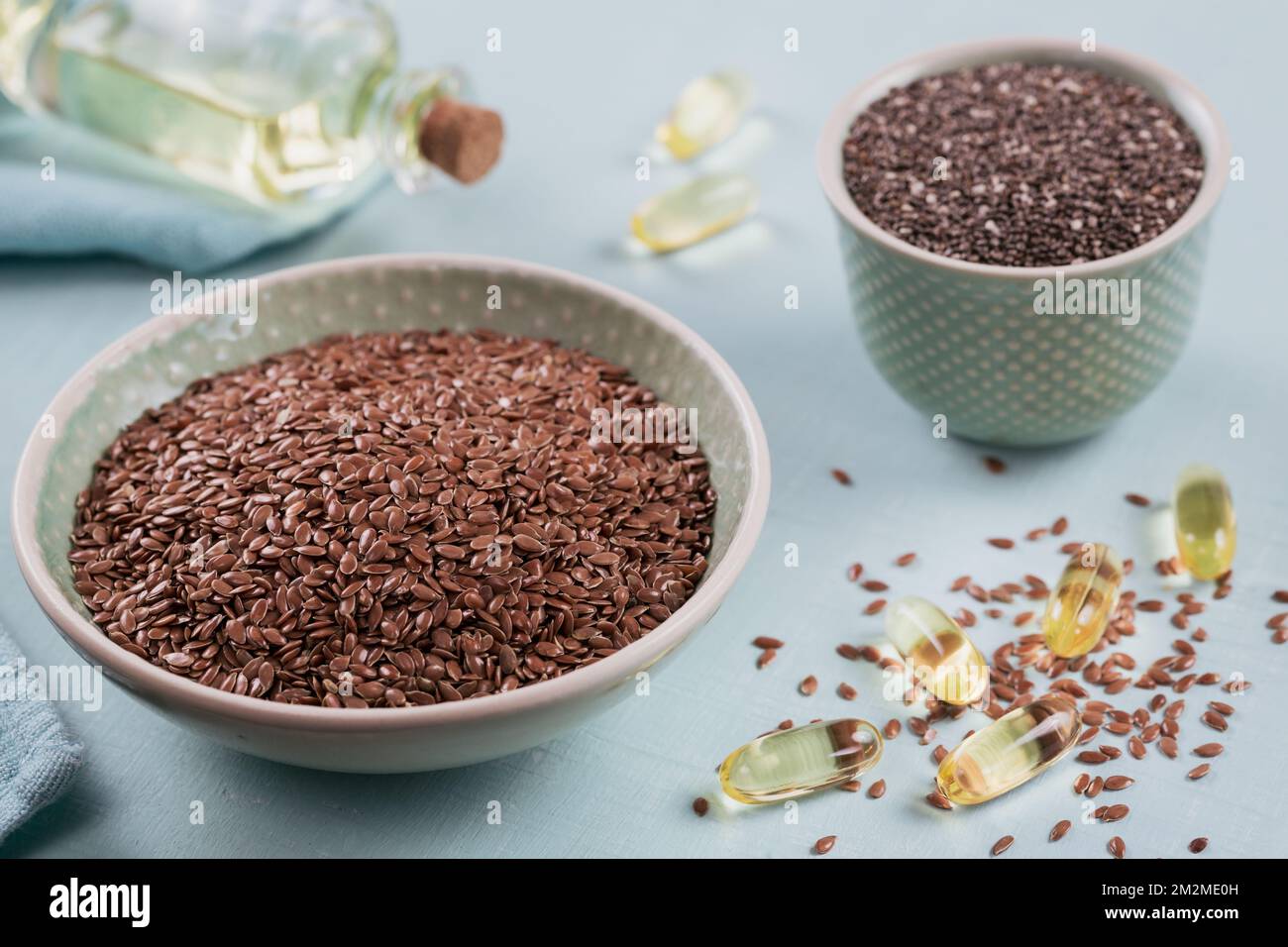Brown flax seed or linseed and chia in small bowl and gelatin capsules