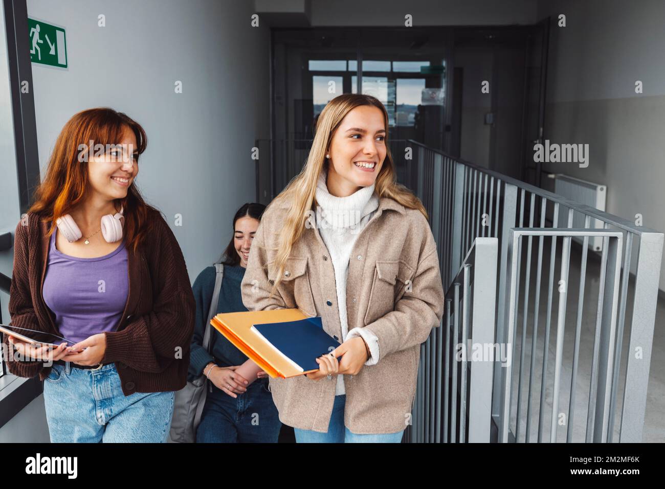 Group of friends, thre young woman laughing while walking in the college dorm Stock Photo