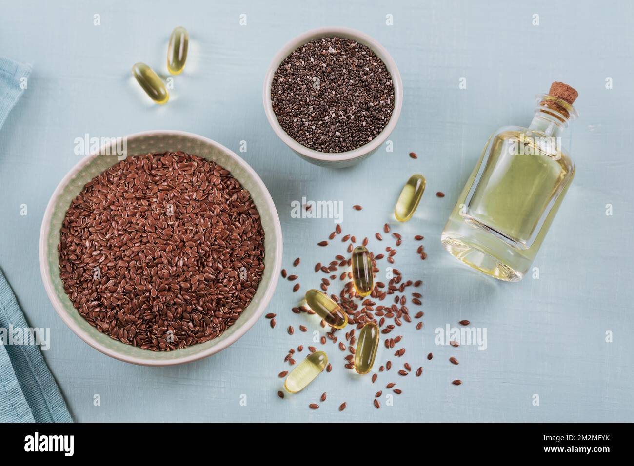 Brown flax seed or linseed and chia in small bowl and gelatin capsules