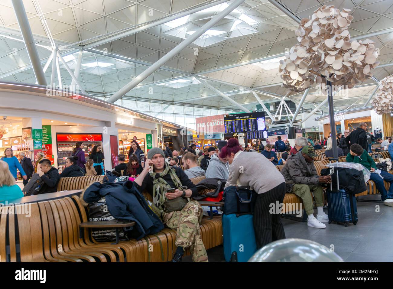 Passengers in departure lounge waiting area, Stansted airport, Essex, England, UK Stock Photo