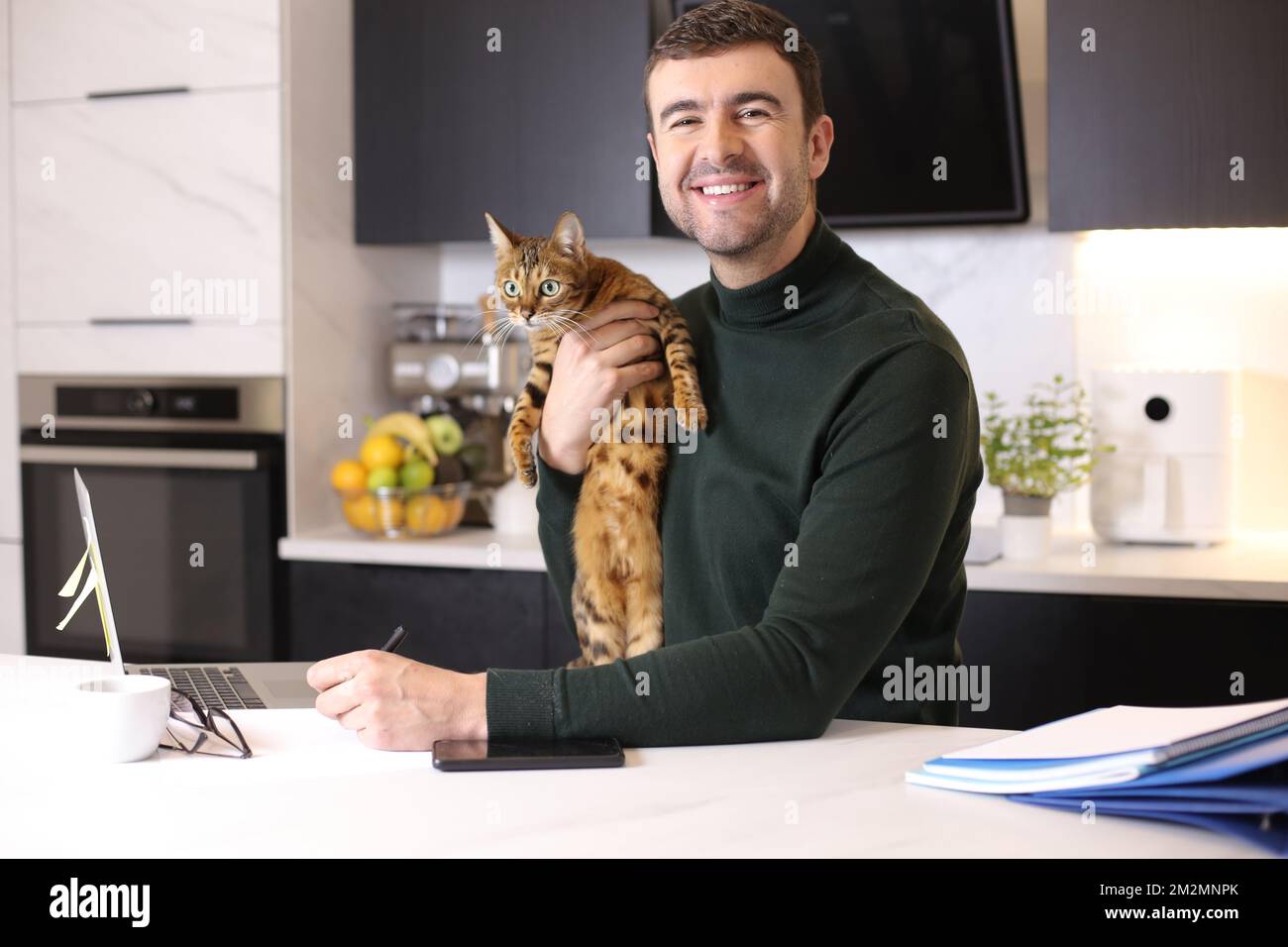 Attractive man working from home with his cat Stock Photo