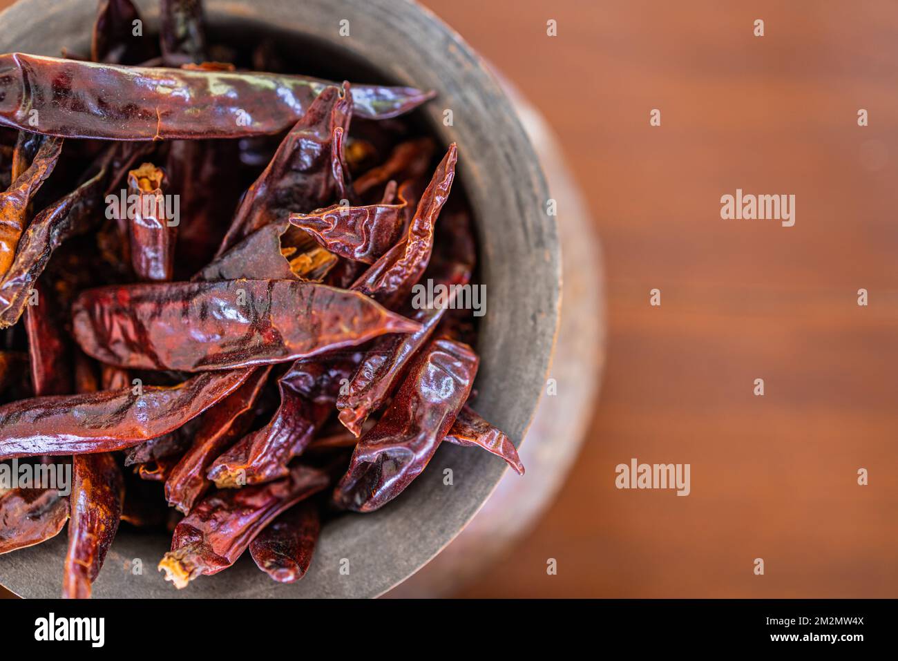 Top view closeup dry red chili peppers on brown wooden table. Dried red chili peppers closeup, traditional food ingredients. Macro raw Stock Photo
