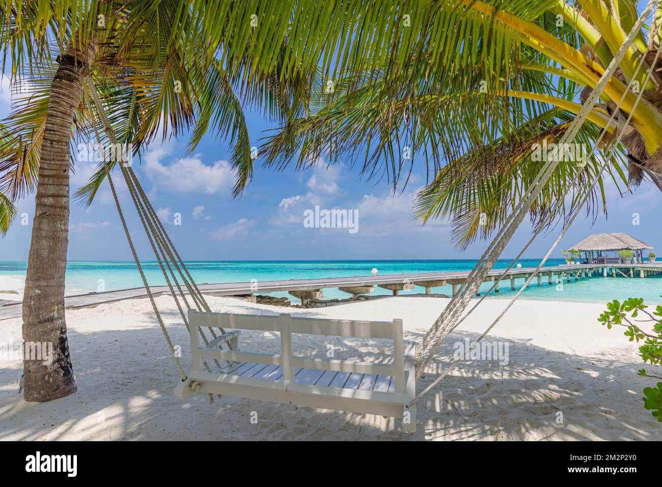 Tropical beach, summer landscape with beach swing or hammock over white sand, close to calm sea for serene beach. Luxury beach scene vacation summer Stock Photo