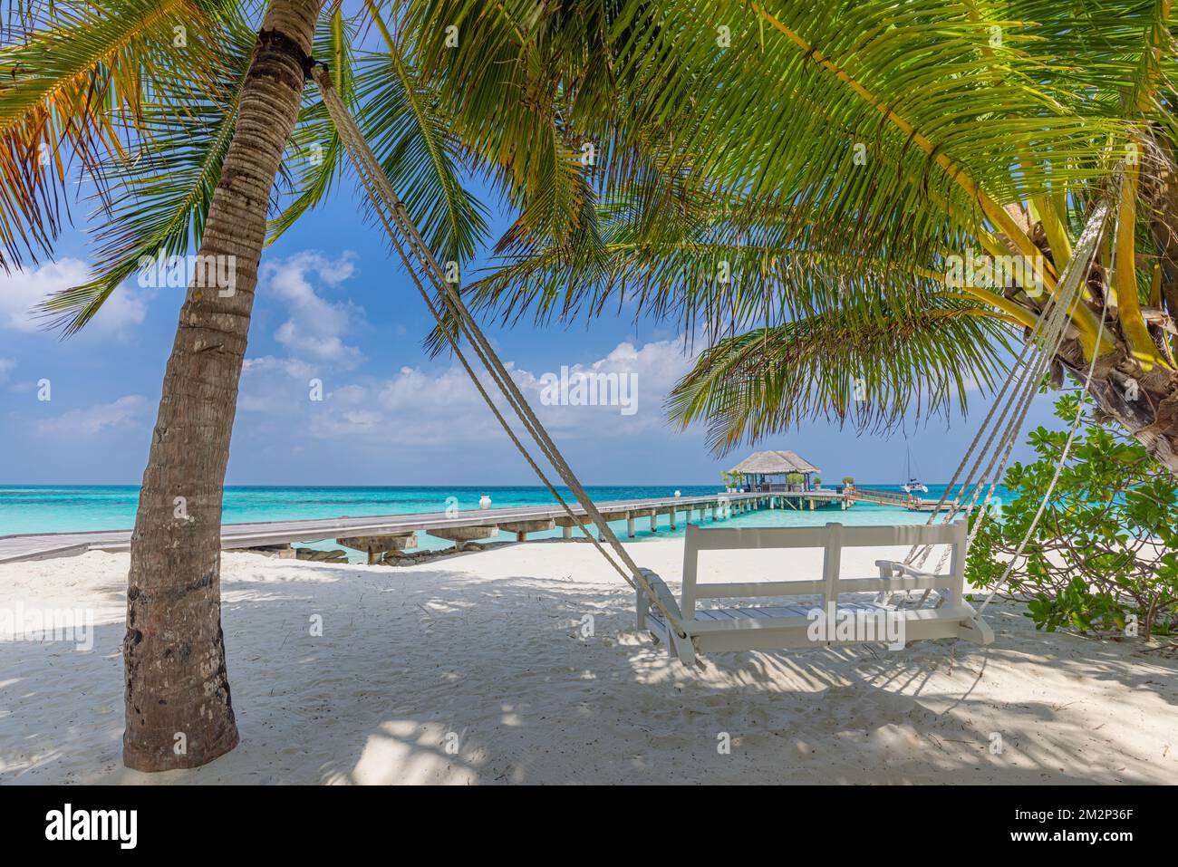 Tropical beach, summer landscape with beach swing or hammock over white sand, close to calm sea for serene beach. Luxury beach scene vacation summer Stock Photo