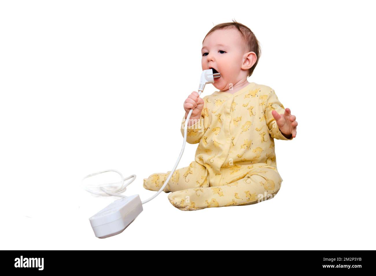 Toddler baby boy gnaws electrical wires while sitting on the floor