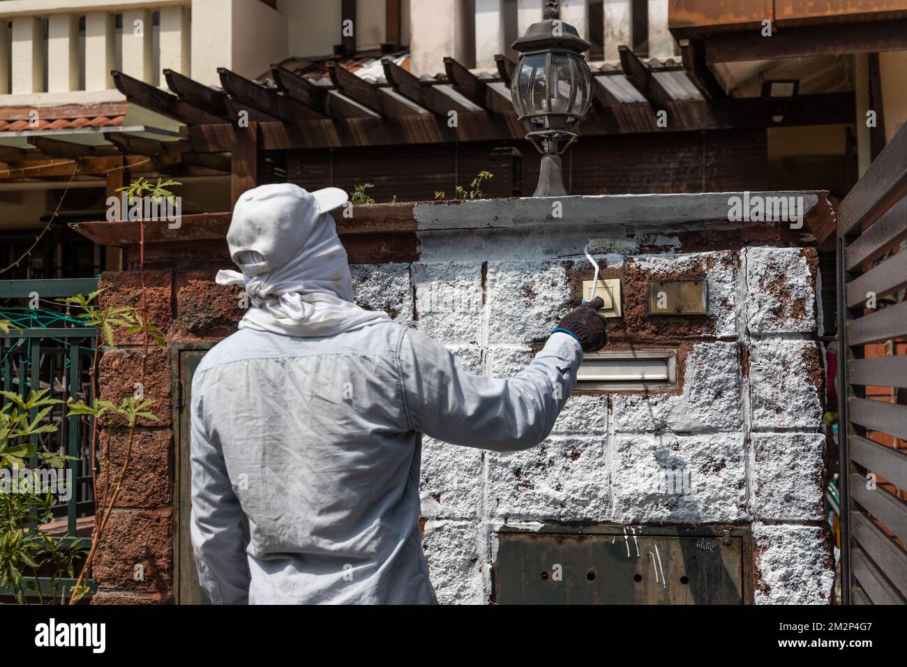 Painter worker adding undercoat foundation paint onto wall with roller