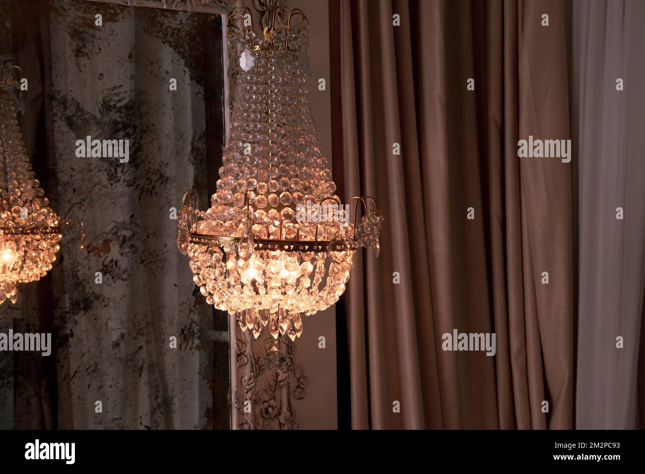 Crystal old chandelier hanging near the mirror at home, vintage interior, chandelier Stock Photo