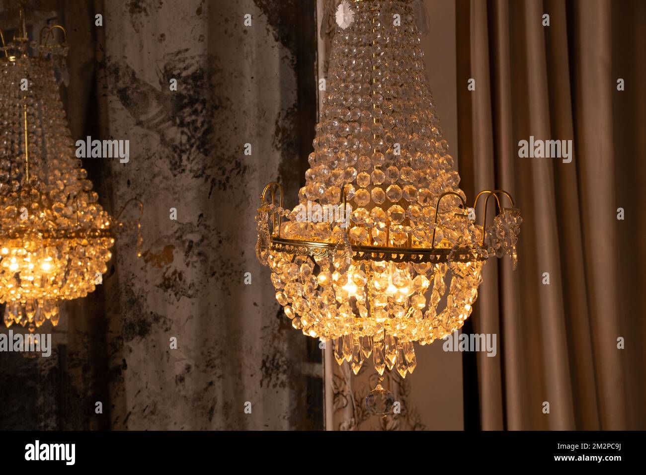 Crystal old chandelier hanging near the mirror at home, vintage interior, chandelier Stock Photo
