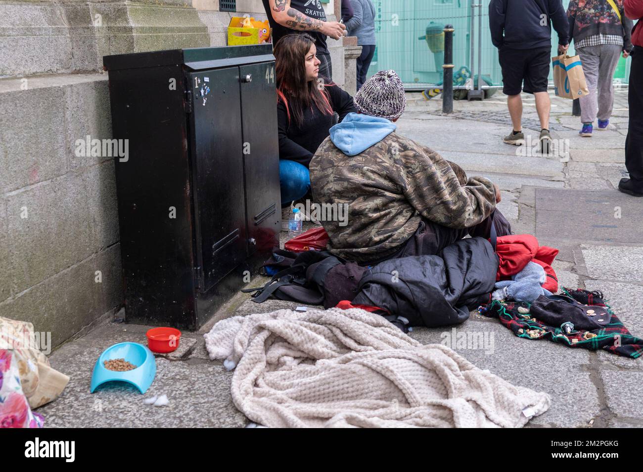 A homeless person sitting on the pavement in Truro City centre in Cornwall in the UK. Stock Photo