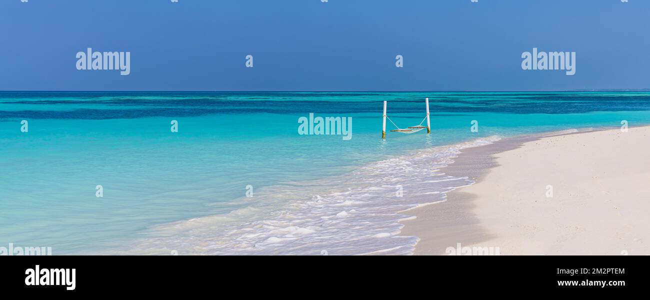 Luxury beach. Tranquil travel background. Summer vacation or holiday concept on tropical beach white sand and amazing over water hammock over blue bay Stock Photo