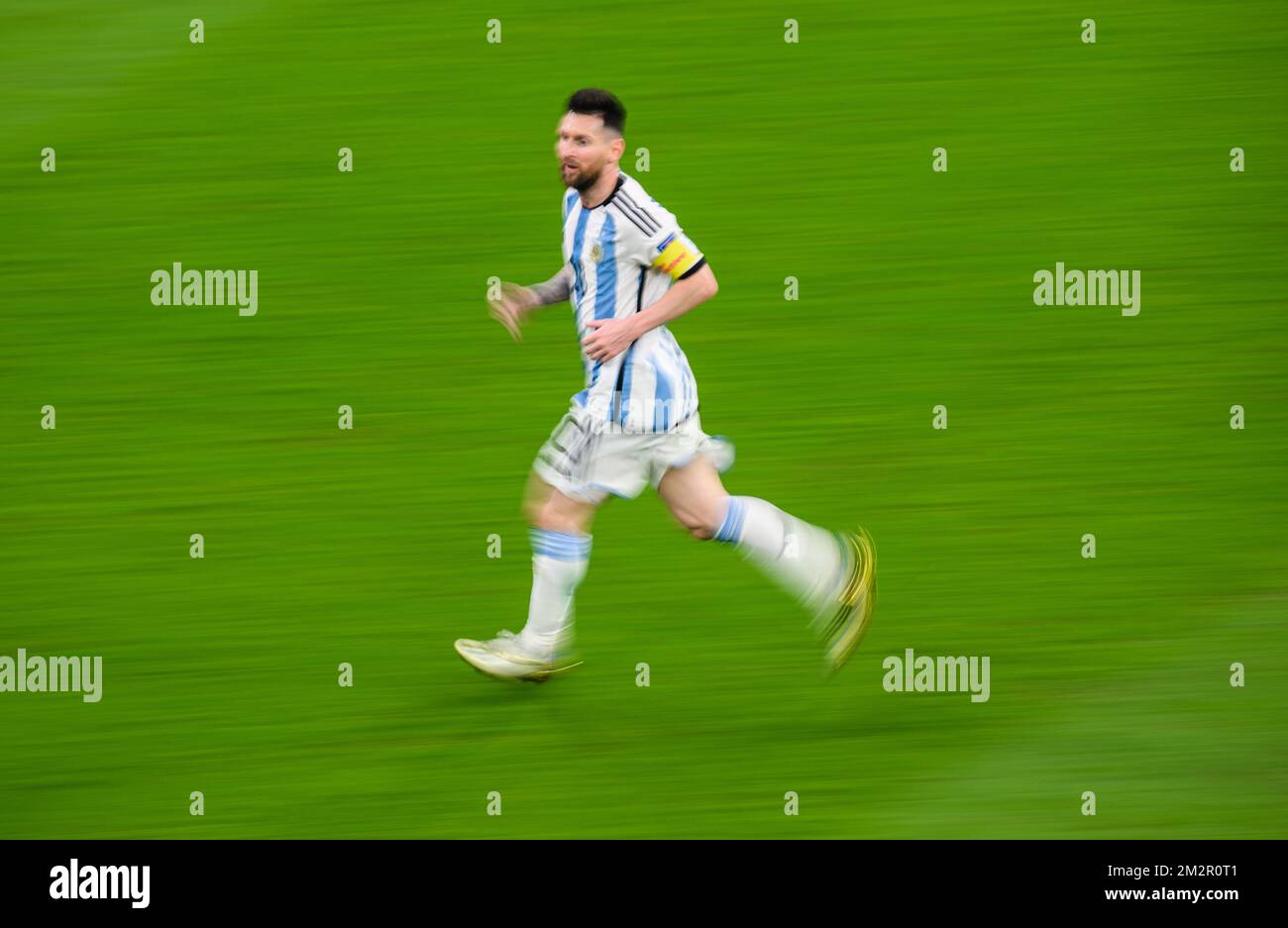 Lusail, Qatar. 13th Dec, 2022. Soccer, World Cup, Argentina - Croatia, final round, semi-final, Lusail Stadium, the stadium before the match. Argentina's Lionel Messi runs across the field. (shot with long exposure time) Credit: Robert Michael/dpa - IMPORTANT NOTE: In accordance with the requirements of the DFL Deutsche Fußball Liga and the DFB Deutscher Fußball-Bund, it is prohibited to use or have used photographs taken in the stadium and/or of the match in the form of sequence pictures and/or video-like photo series./dpa/Alamy Live News Stock Photo