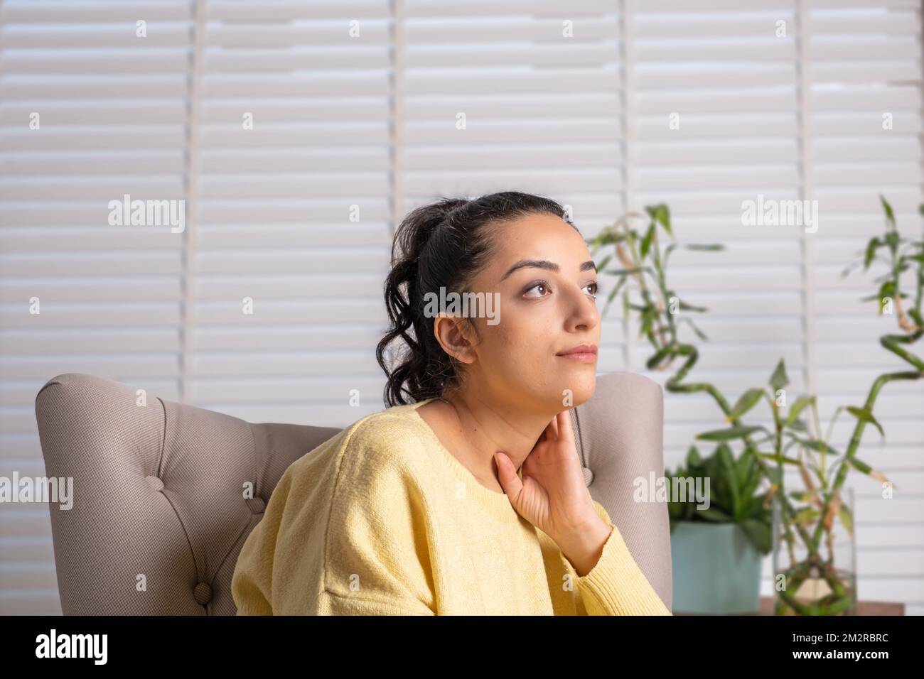 Thoughtful young woman, portrait of caucasian thoughtful young woman. Sitting on arm chair, looking distance , anxious and unhappy. personal problems. Stock Photo