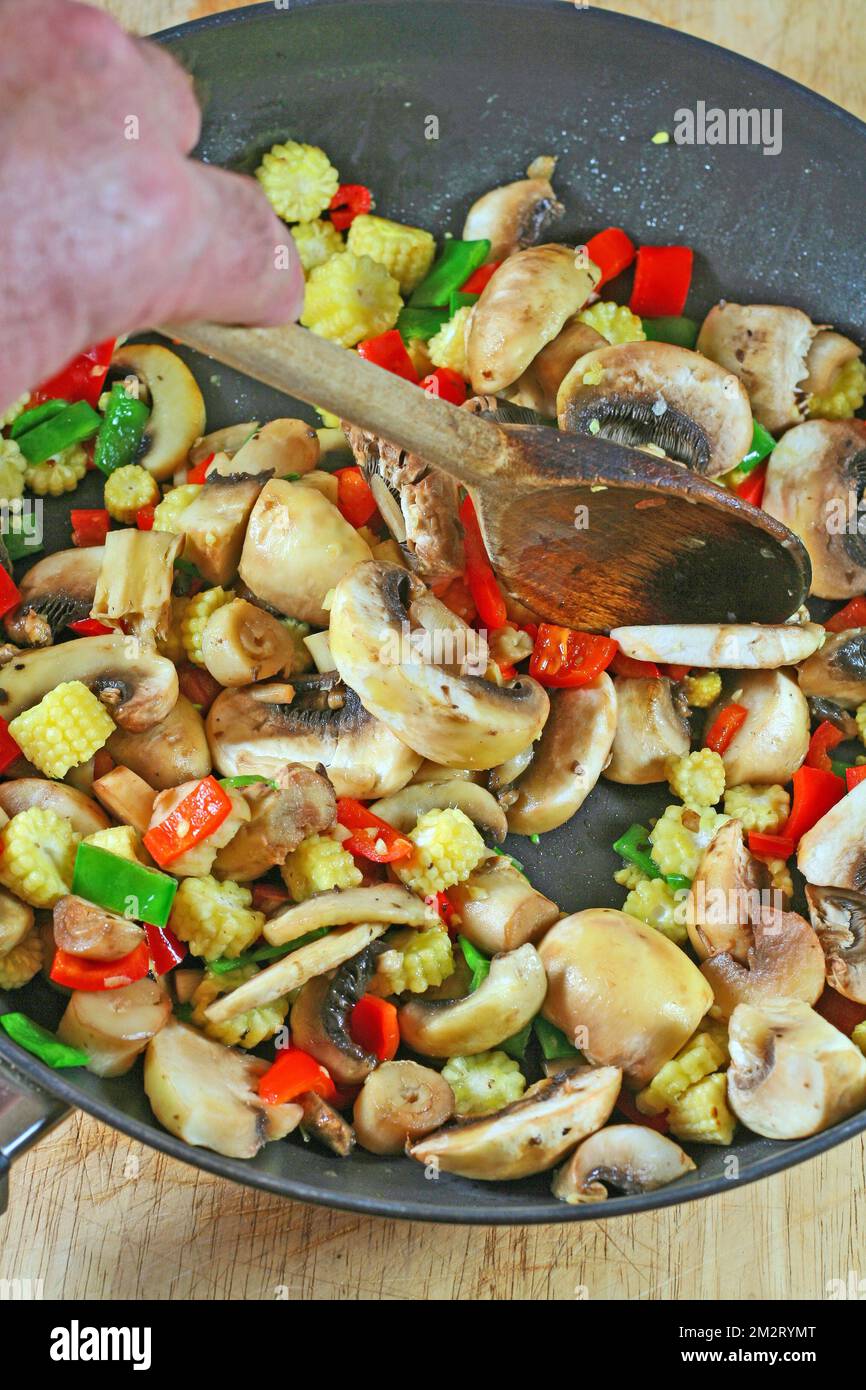 cooking stir fry vegetables. Stirring chopped vegetables in a pan Stock
