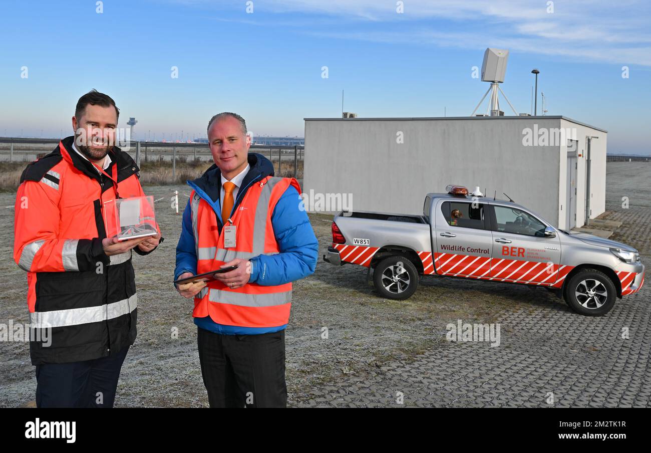 14 December 2022, Brandenburg, Schönefeld: Thomas Hoff Andersson (l), Managing Director Operations of Flughafen Berlin Brandenburg GmbH, and Siete Hamminga, CEO of Robin Radar Systems, stand in front of the new radar system to protect against bird strikes at BER Airport. The 3D radar can detect flocks of birds at a distance of 15 kilometers around the airport. Pyrotechnic systems can then be triggered at the touch of a button to keep the birds away from the runways. The new radar system is supported by Wildlife Control staff on the ground. Photo: Patrick Pleul/dpa Stock Photo