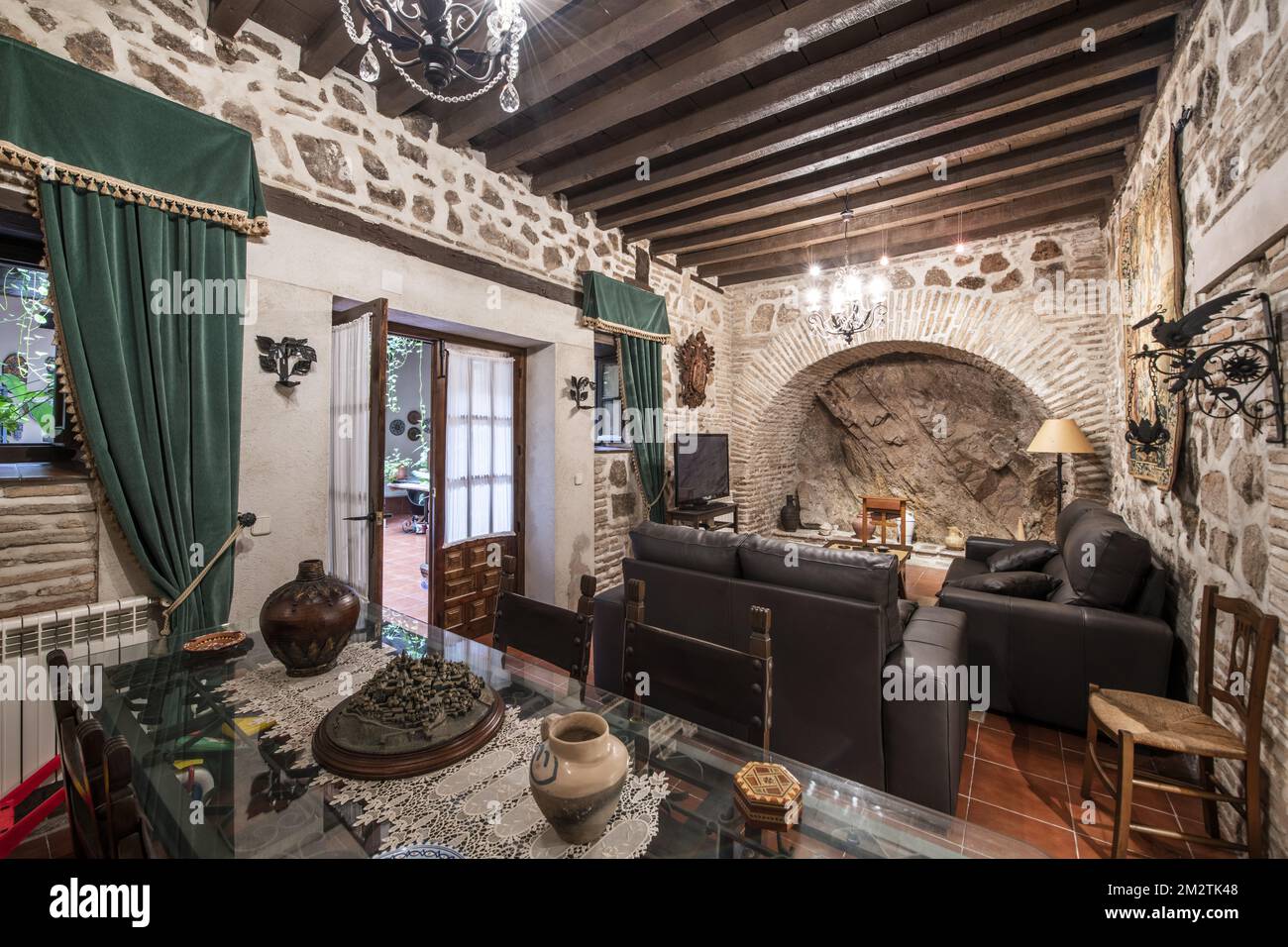 Living room with ornate decoration of a vintage house with stone and mortar walls and wooden paneled ceilings Stock Photo