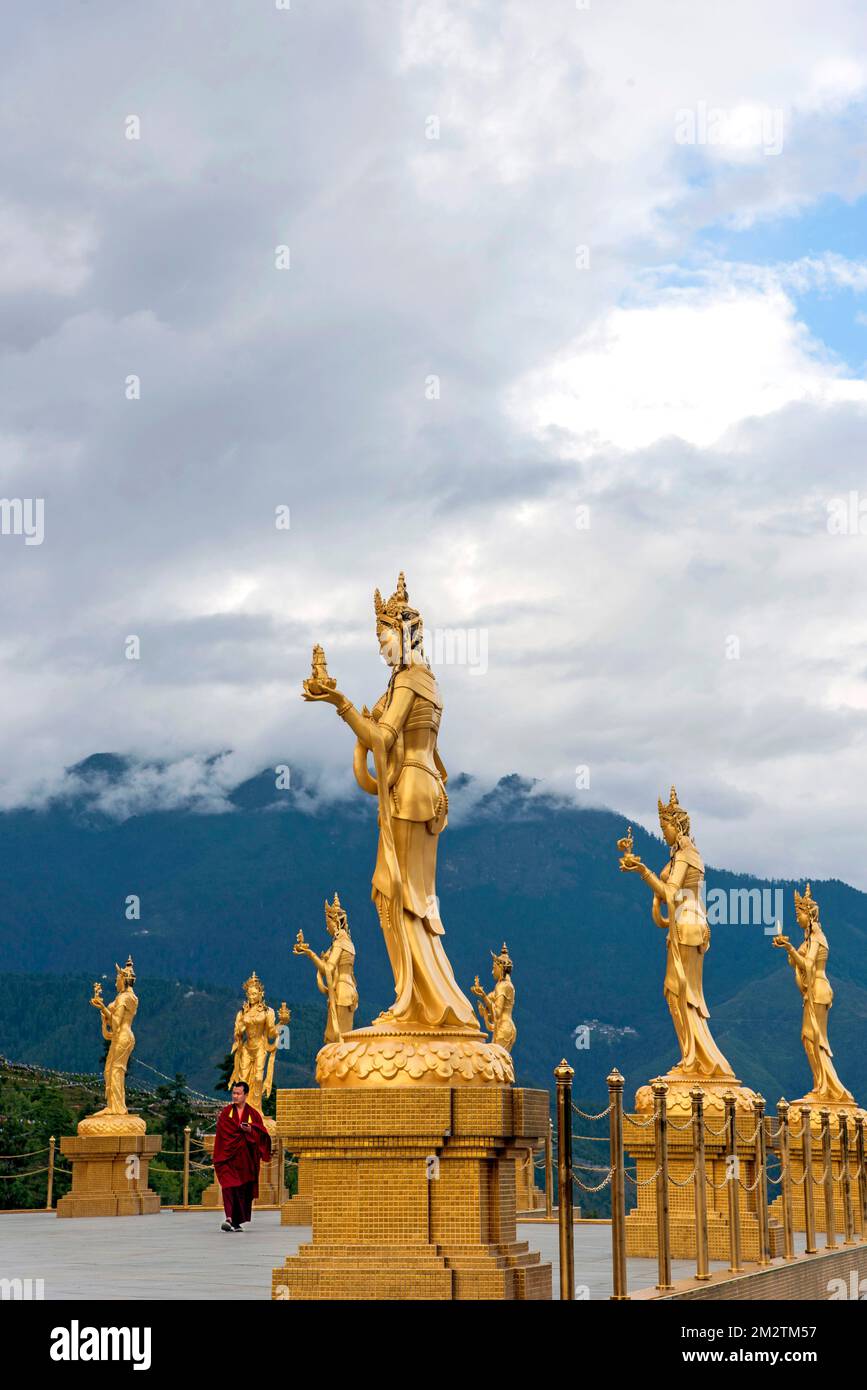monk amidst golden Statues of Buddhist Female Gods at Buddha Dordenma Temple, Thimphu, Bhutan Stock Photo