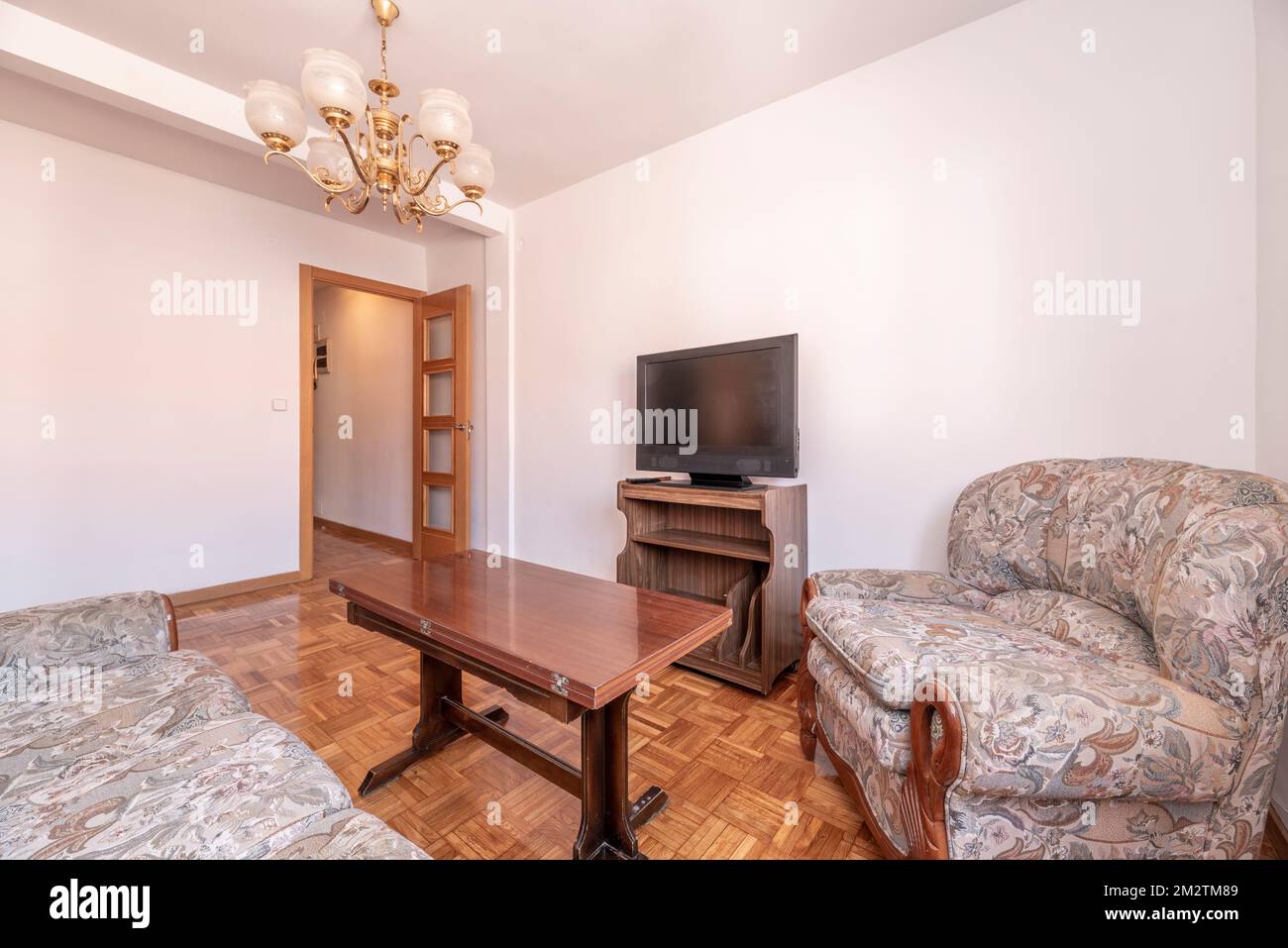 Living room of a house with outdated furniture with old tv and checkerboard parquet floors Stock Photo