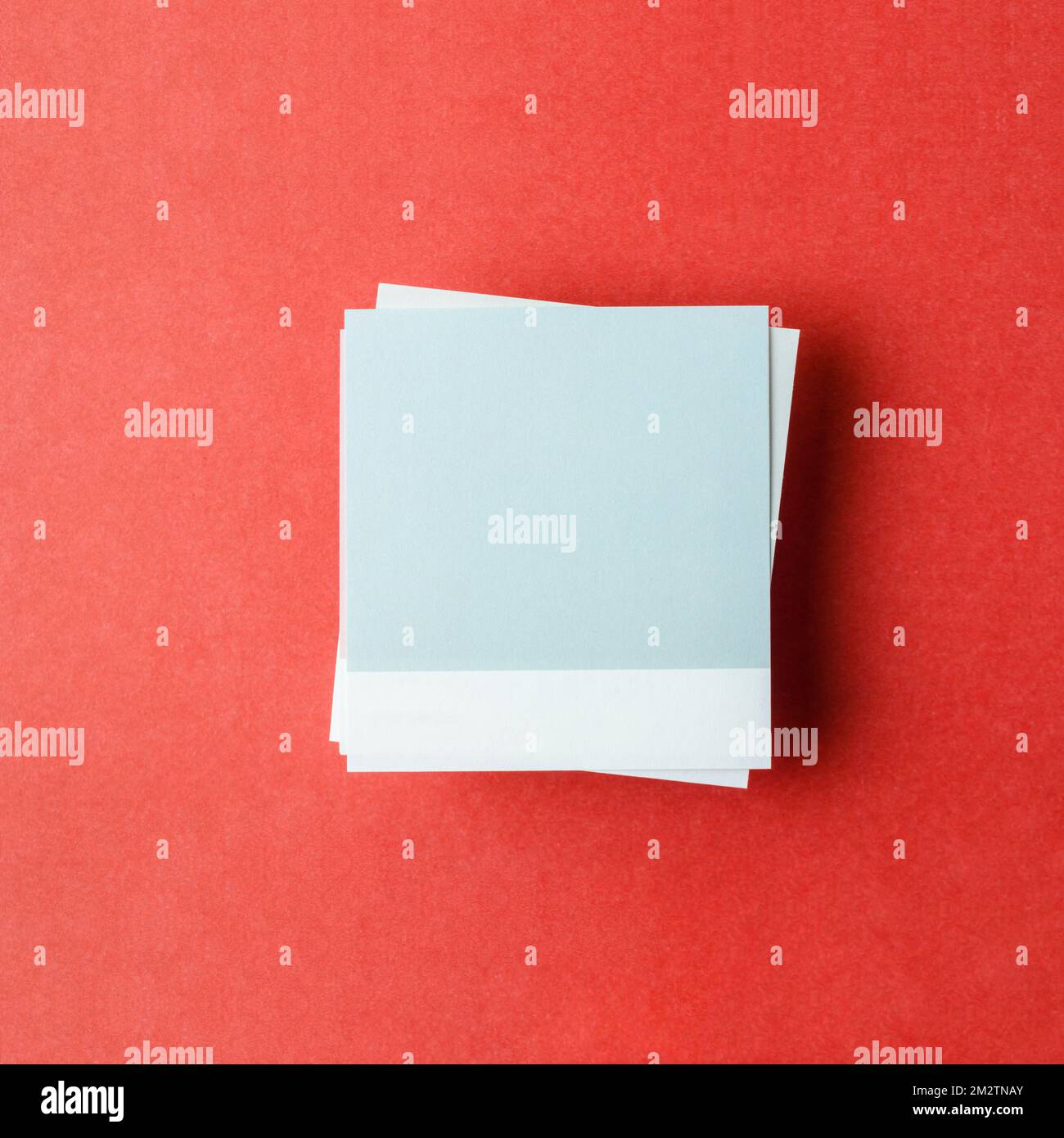 Blank paper note for your text or message on red background, top view. Stock Photo
