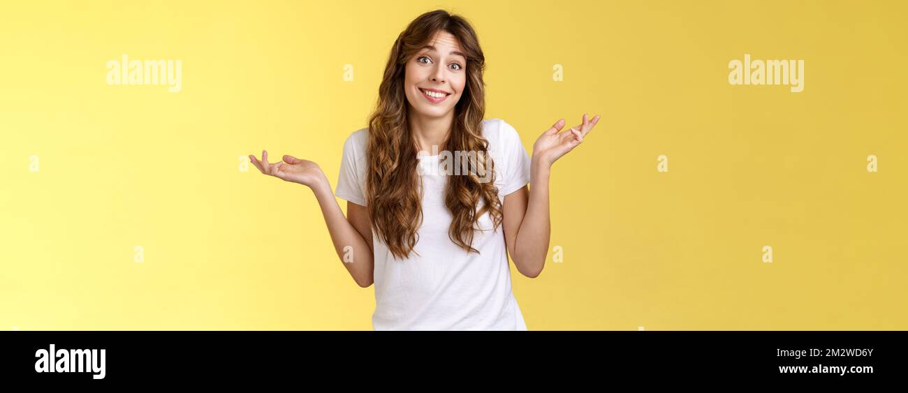 Who cares have fun. Carefree indifferent outgoing happy young woman shrugs raise hands sideways clueless unbothered apathic to topic uninterested Stock Photo