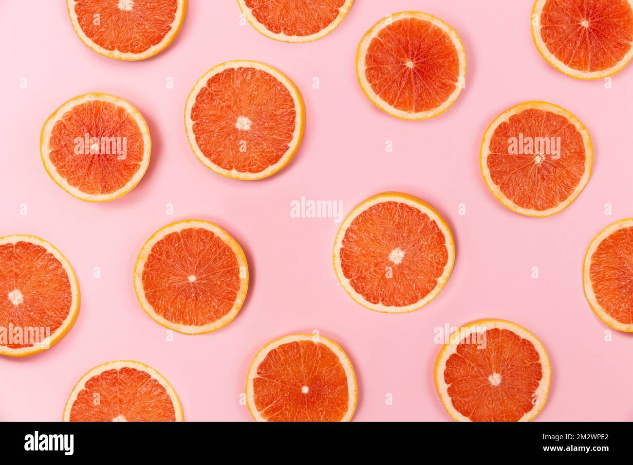grapefruit slices on pink background Stock Photo