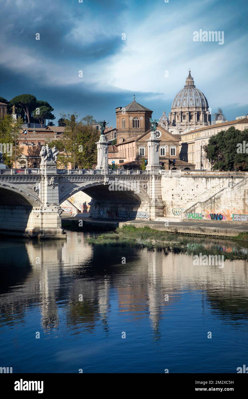 The Tibor River flows through Rome with St. Peters Basilica of Vatican City rising in the background. Stock Photo