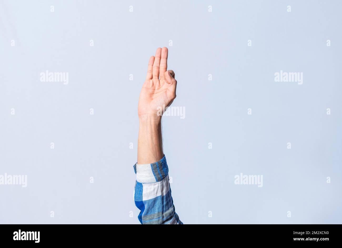 Hand gesturing the letter F in sign language on isolated background. Man hand gesturing the letter F of the alphabet isolated. Letters of the Stock Photo