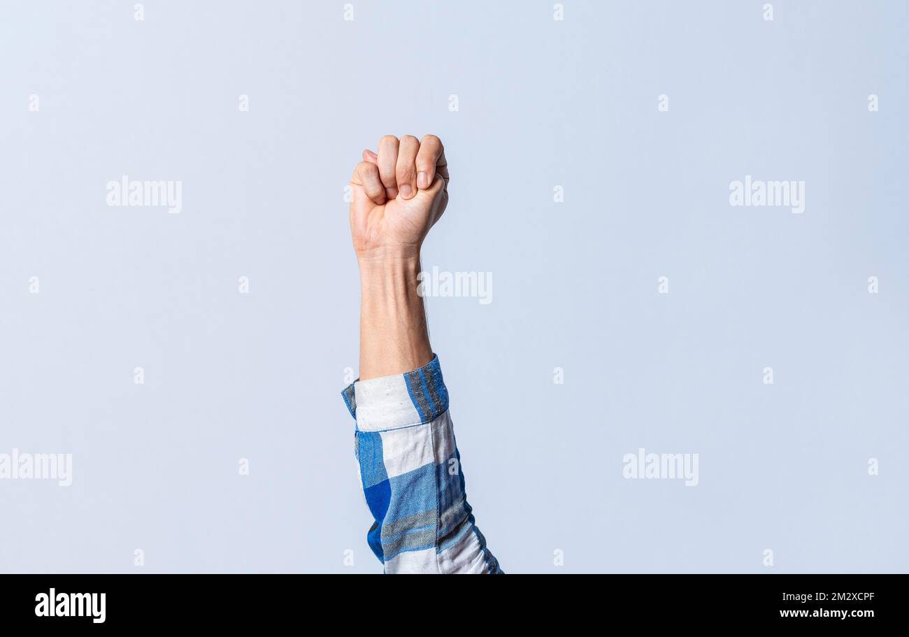 Hand gesturing the letter M in sign language on an isolated background. Man's hand gesturing the letter M of the alphabet isolated. Letter M of the Stock Photo