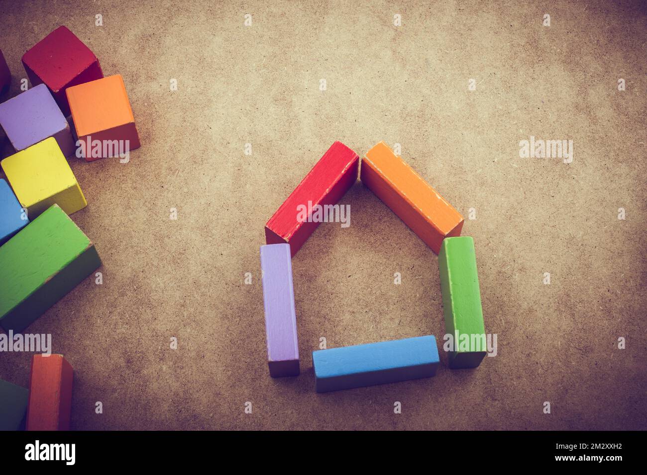 House shape formed out of building blocks on a brown background Stock Photo