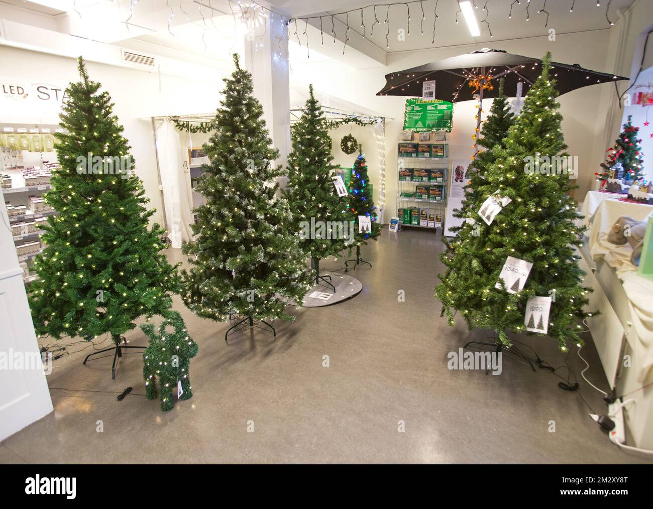 Plastic Christmas trees with lighting for sale in store Stock Photo Alamy