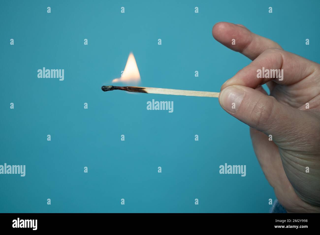 Burning match. Flame on the head and matchstick, on a blue background