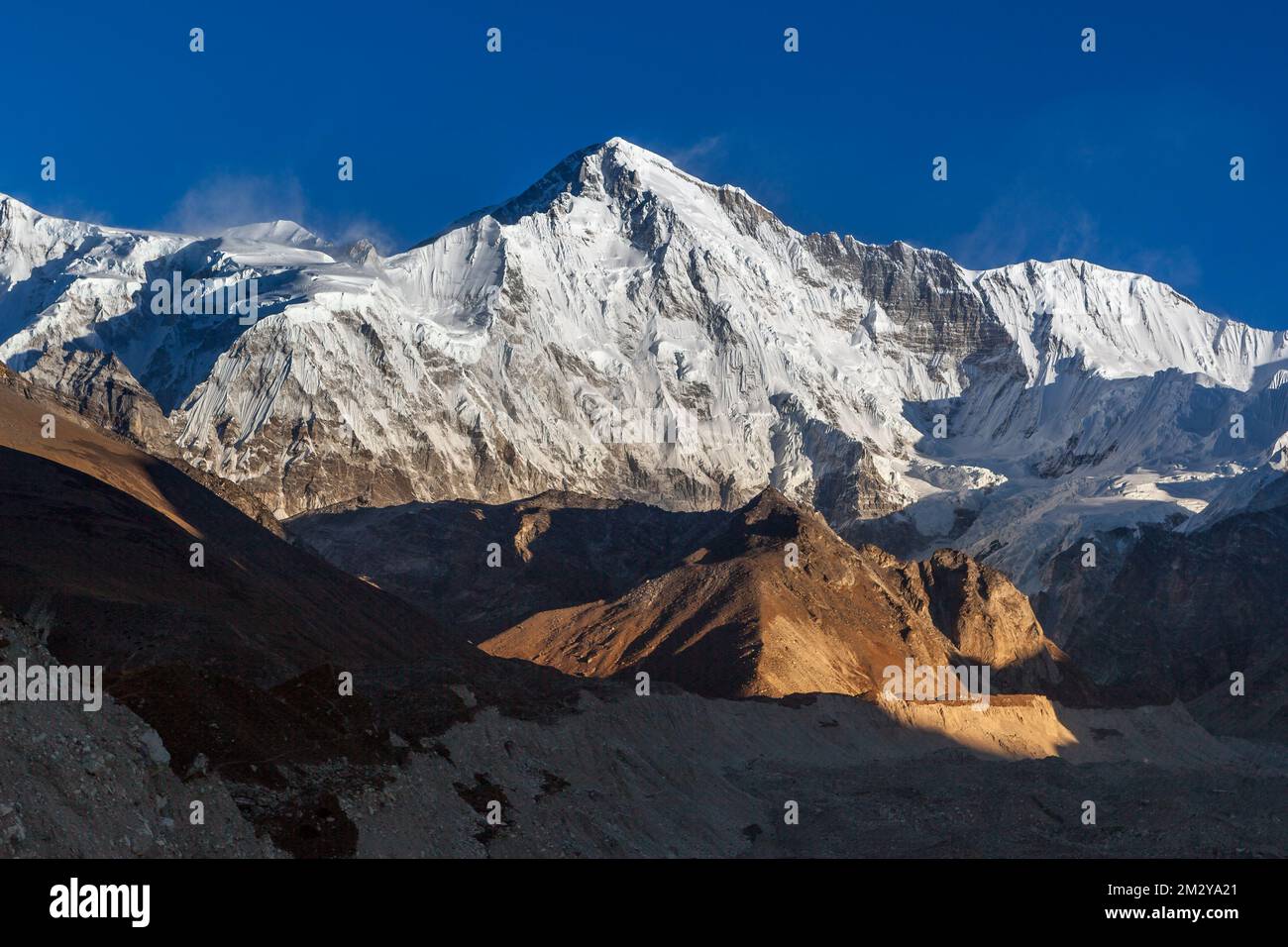 Cho Oyu mountain peak lit up by the sun lights at sunset. Beautiful landscape on a clear day high in the Himalayan mountains, Sagarmatha National Park Stock Photo