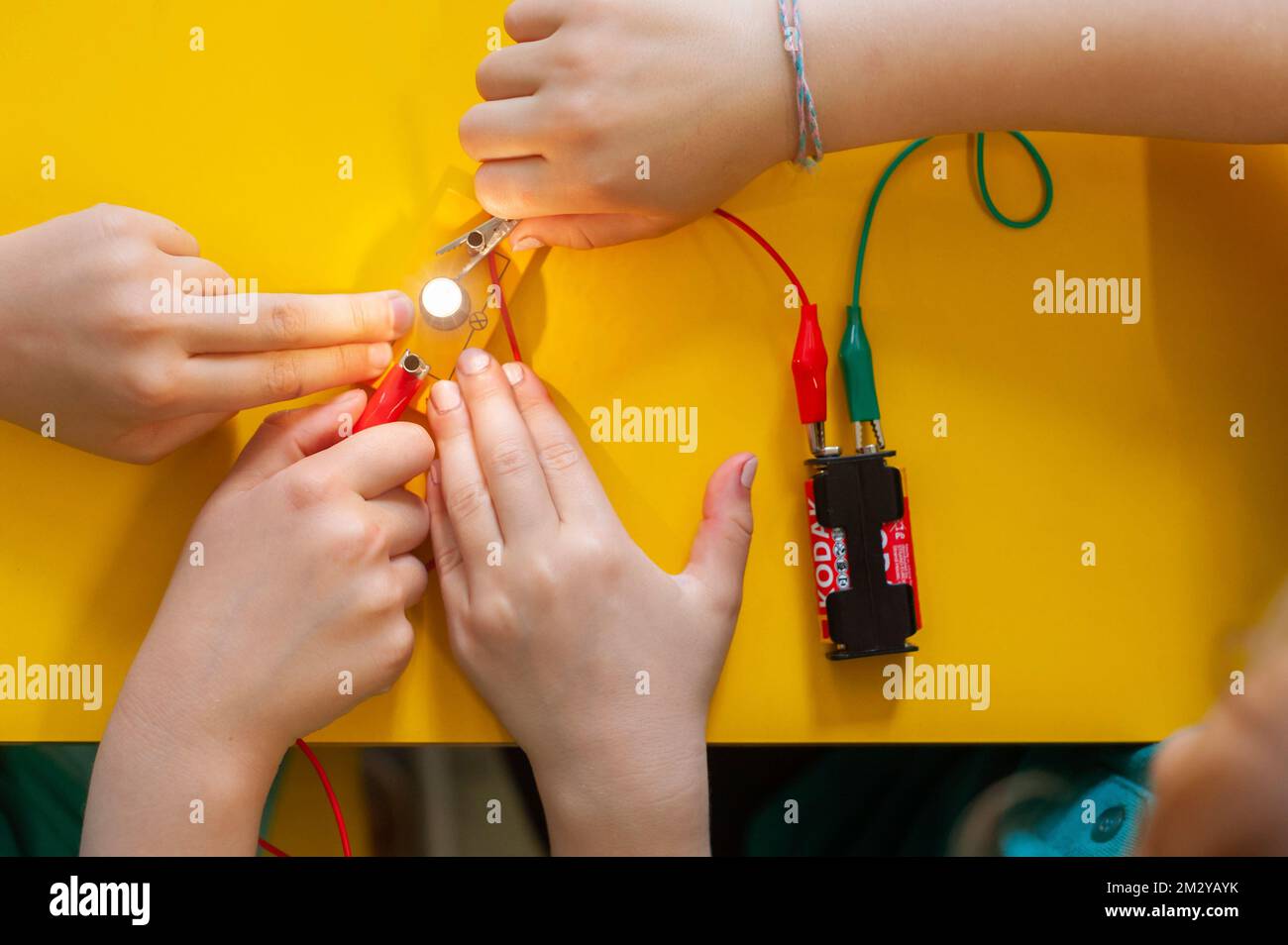 Close up of school children making circuits with light bulb in practical science lesson Stock Photo