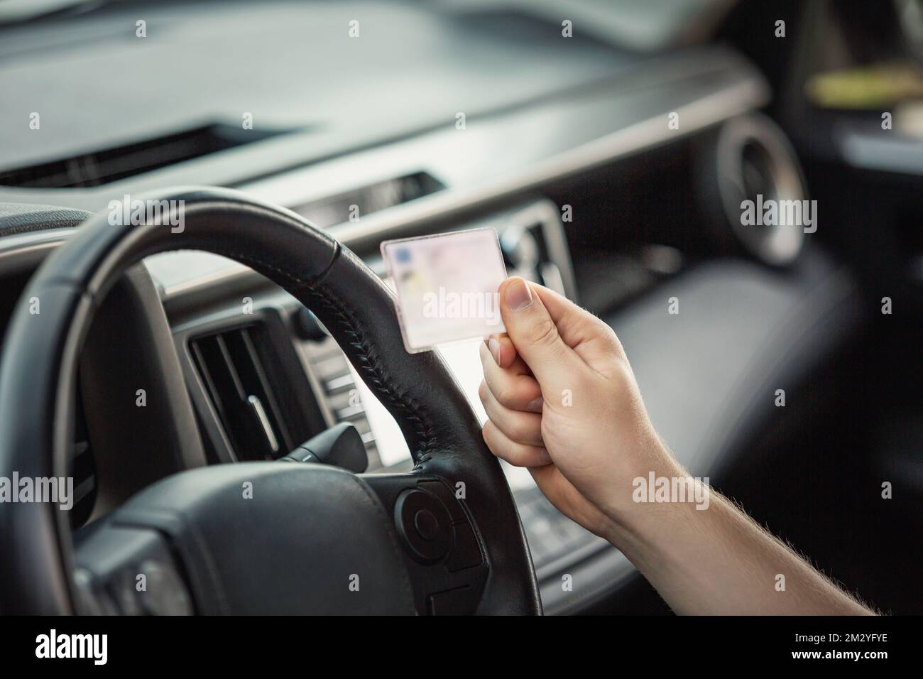 Close up person hand holding the driver license in front of the