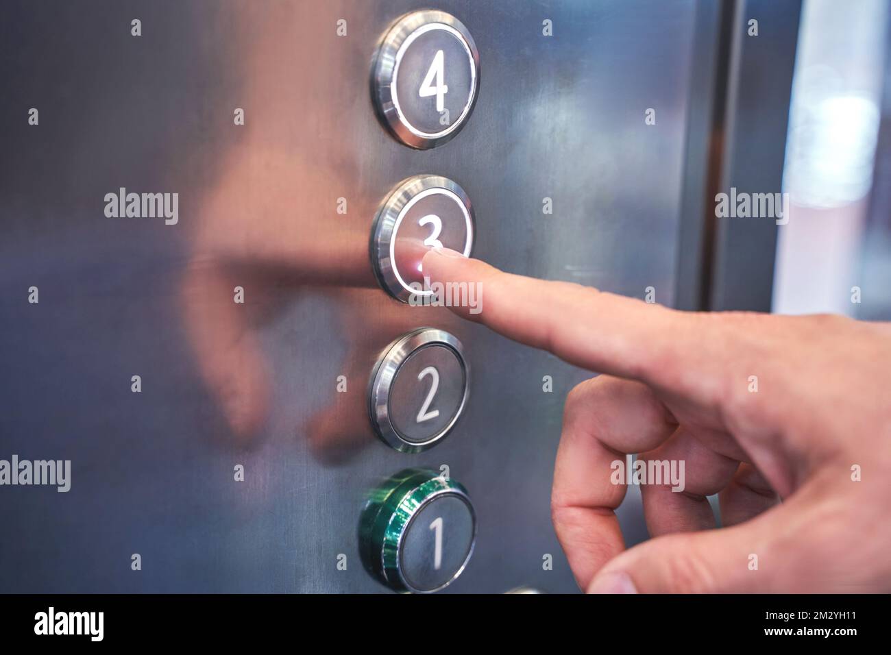Man hand pointing number 3 button in elevator. Steel interior panel. Change year concept. Waiting new step. Up action. Start claustrophobia moment. Moving click Stock Photo