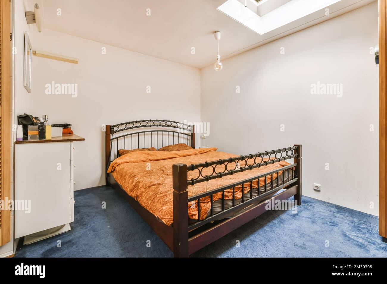 a bedroom with a bed, refrigerator and microwave on the wall in front