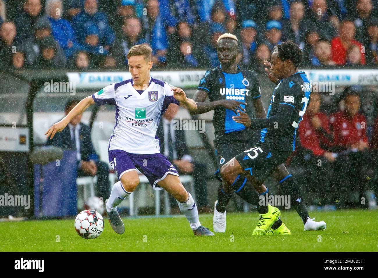 Club's Percy Tau and Anderlecht's Derrick Luckassen fight for the