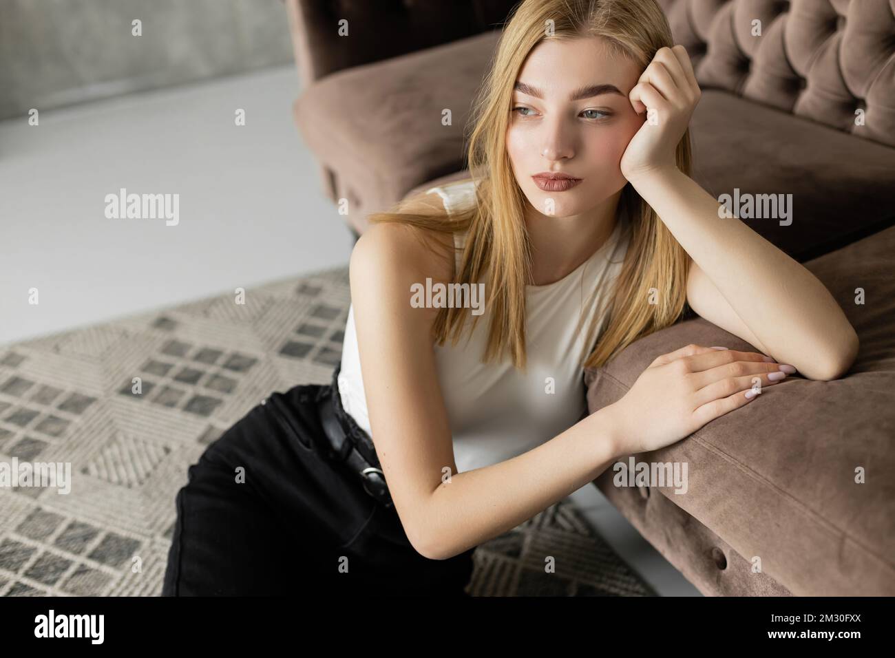Sad young blonde woman sitting hi-res stock photography and images - Alamy