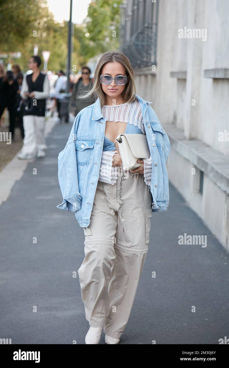 MILAN, ITALY - SEPTEMBER 22, 2022: Woman with blue sunglasses and denim jacket before Prada fashion show, Milan Fashion Week street style Stock Photo