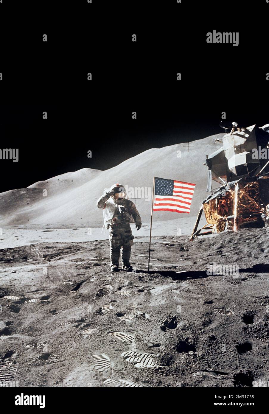 The Moon's surface. Astronaut David R. Scott gives a military salute while standing beside the deployed United States flag during the Apollo 15 lunar surface extravehicular activity (EVA) at the Hadley-Apennine landing site. The flag was deployed toward the end of EVA-2. The Lunar Module (LM), 'Falcon,' is partially visible on the right. Hadley Delta in the background rises c.4000m (about 13124ft) above the plain. This photograph was taken by astronaut James B. Irwin, lunar module pilot.  A unique optimised version of a NASA image. Credit: JB Irwin/NASA Stock Photo